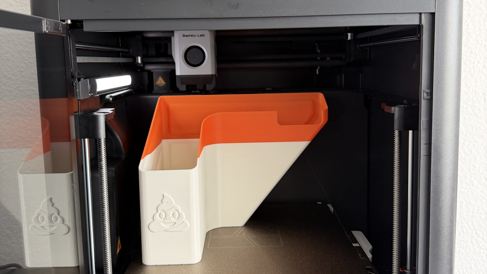 Bambu Lab P1S 3D-Drucker mit AMS und frisch gedrucktem Poop-Chute (Auffang-Behälter mit Kackhaufen-Emoji) und Tablet-Halter